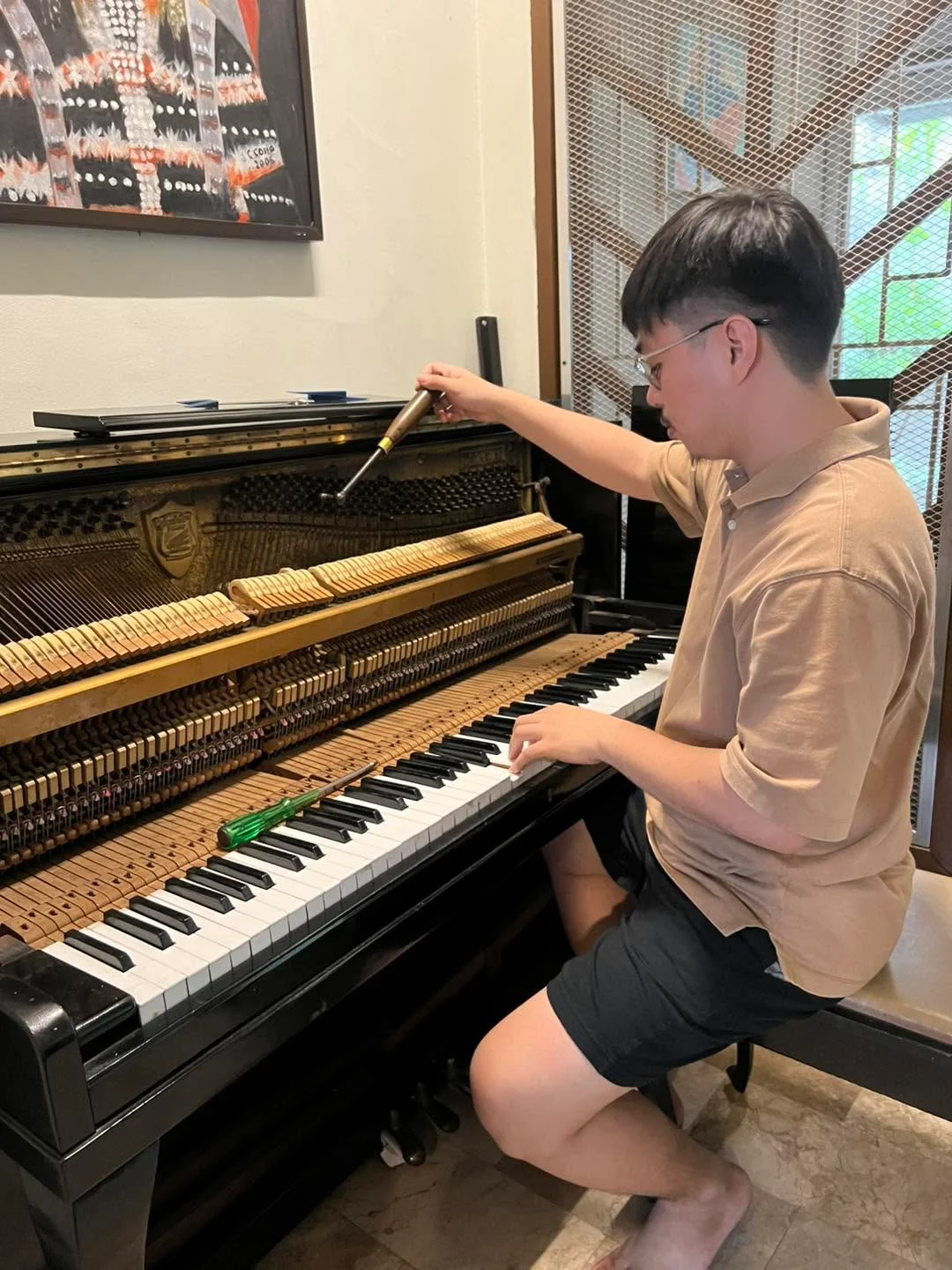 Technician tuning an upright piano